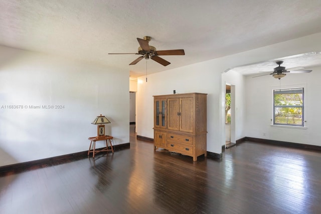 spare room featuring a textured ceiling, dark wood-type flooring, and ceiling fan