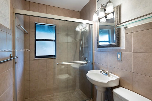 bathroom featuring toilet, tile walls, and an enclosed shower