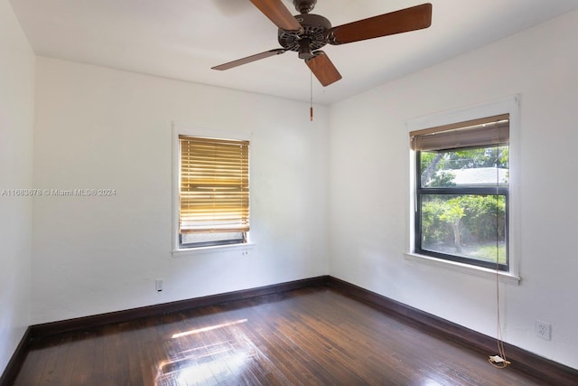 empty room featuring dark wood-type flooring and ceiling fan