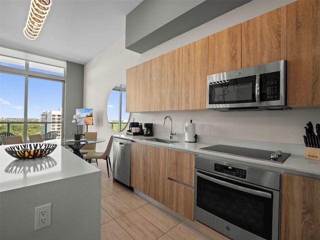 kitchen with appliances with stainless steel finishes, sink, and light tile patterned floors