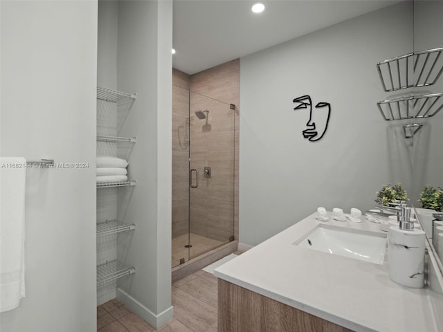 bathroom featuring an enclosed shower, wood-type flooring, and vanity