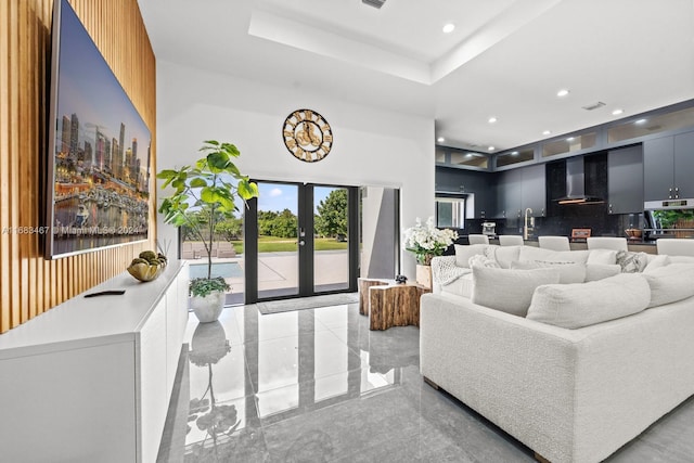 living room featuring french doors and a tray ceiling