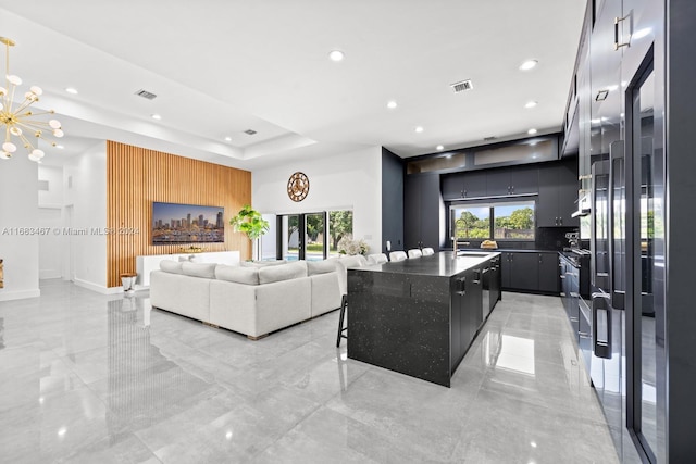 living room featuring a raised ceiling and a notable chandelier