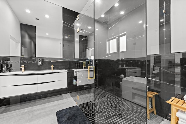 bathroom featuring vanity, an enclosed shower, and tile walls