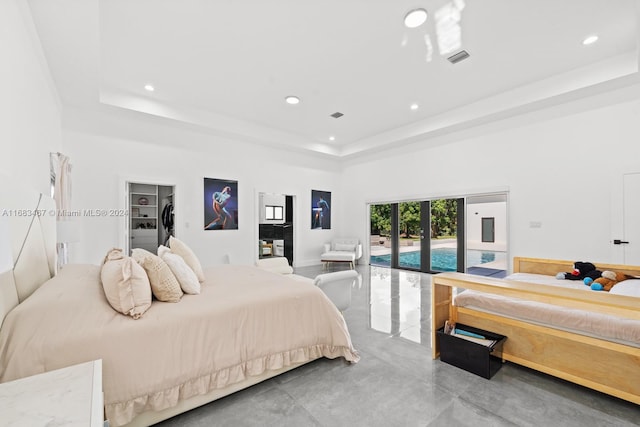 bedroom featuring french doors, a tray ceiling, and a high ceiling