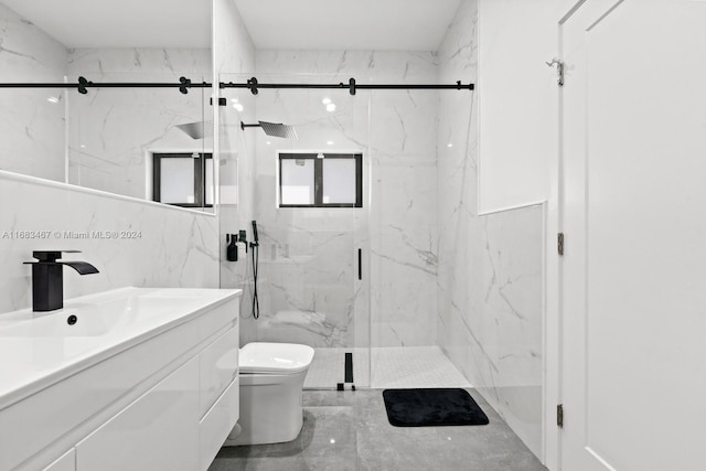 bathroom featuring vanity, toilet, a shower with shower door, and tile walls