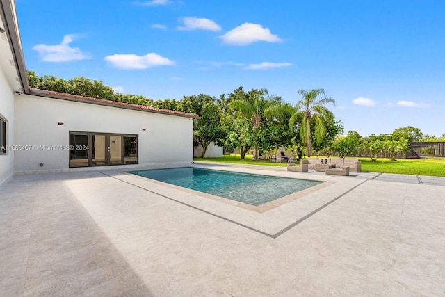 view of swimming pool with outdoor lounge area, a yard, a patio, and french doors