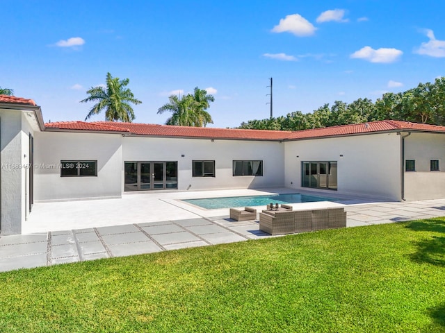 back of house featuring a lawn, an outdoor living space, and a patio