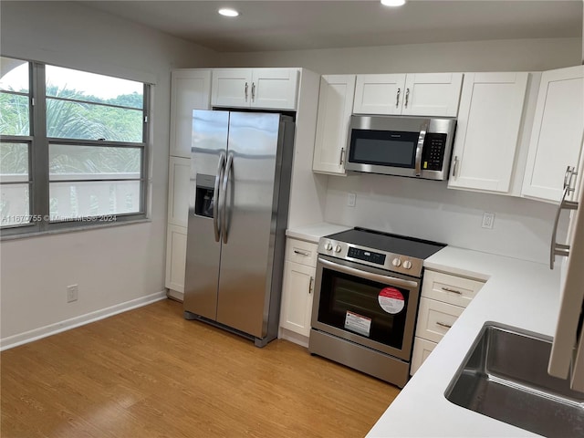 kitchen featuring light hardwood / wood-style flooring, white cabinets, and appliances with stainless steel finishes