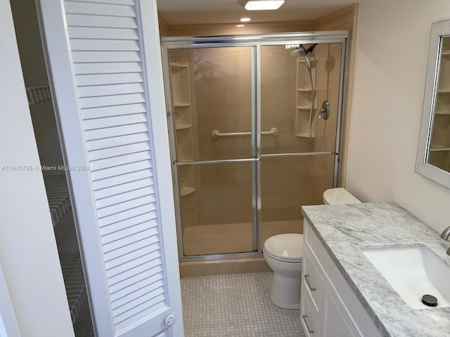 bathroom featuring walk in shower, tile patterned flooring, vanity, and toilet