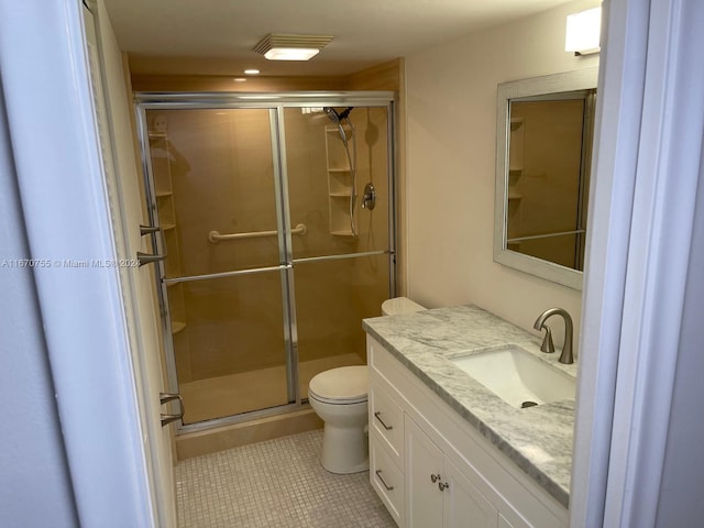 bathroom featuring tile patterned floors, vanity, toilet, and walk in shower