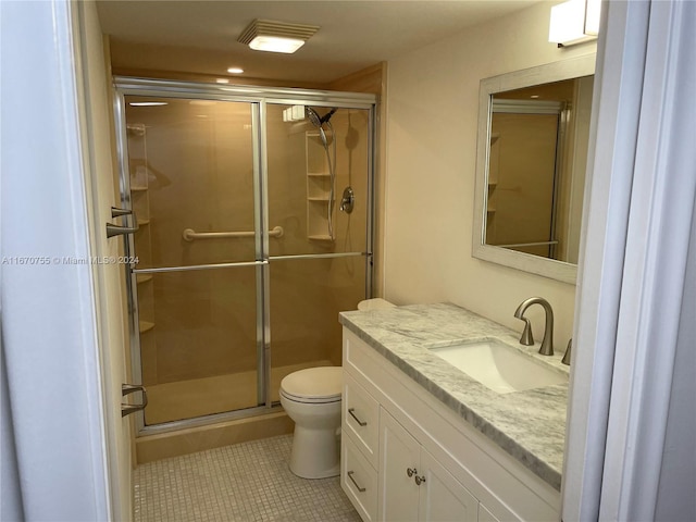 bathroom with tile patterned flooring, vanity, toilet, and an enclosed shower