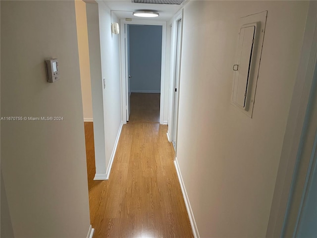 hallway featuring light wood-type flooring and electric panel