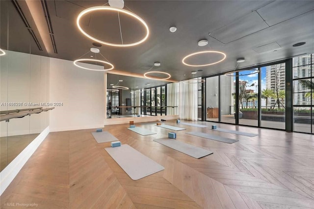 gym featuring a wall of windows and parquet floors