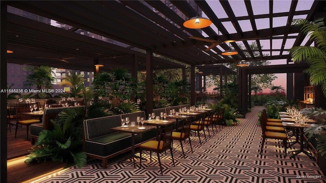 patio terrace at dusk featuring ceiling fan and a pergola