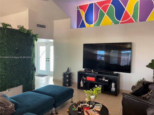 living room featuring light tile patterned flooring, a high ceiling, and french doors