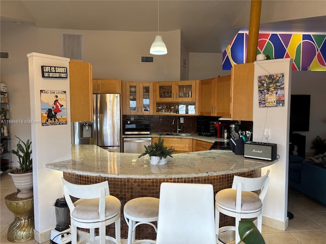 kitchen featuring hanging light fixtures, sink, light tile patterned floors, appliances with stainless steel finishes, and kitchen peninsula