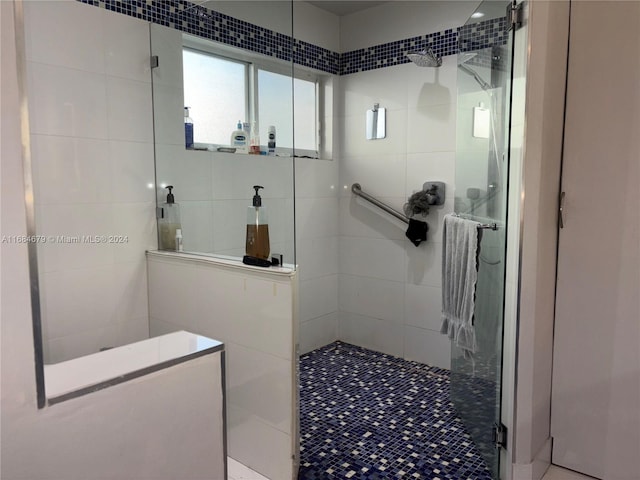 bathroom with tile patterned floors, tile walls, and tiled shower