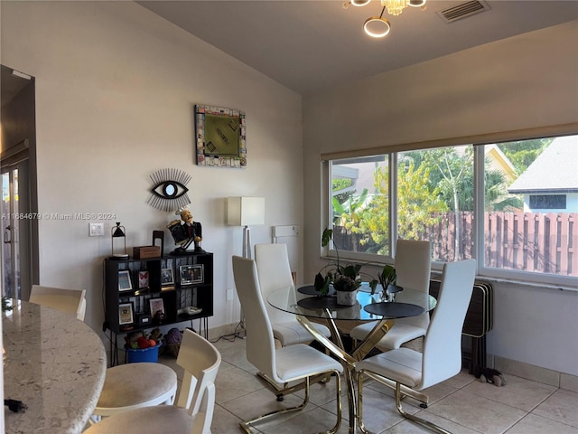 dining space featuring vaulted ceiling and light tile patterned flooring