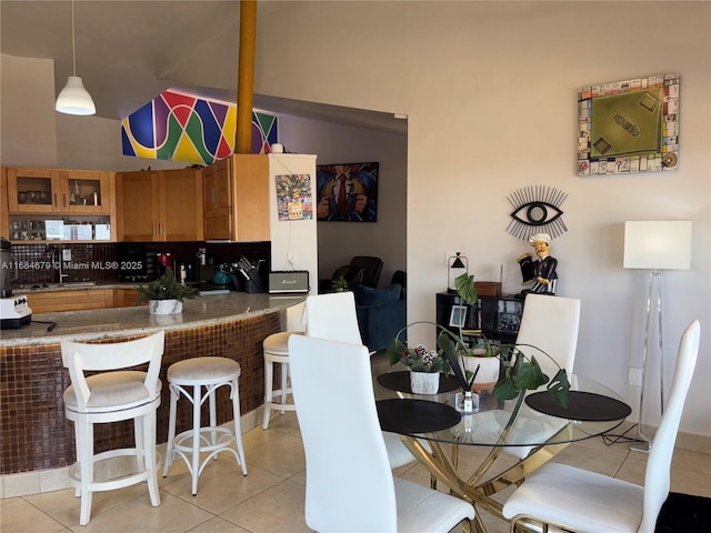dining area featuring light tile patterned floors and lofted ceiling