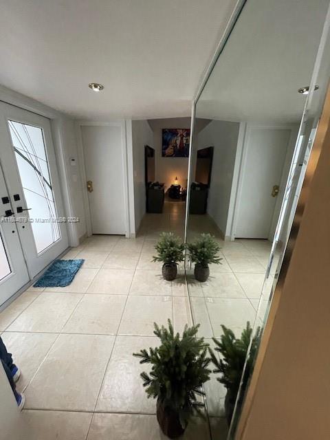 foyer entrance featuring french doors and light tile patterned floors