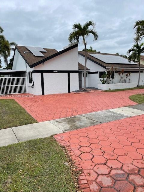 view of front of house with solar panels, a garage, and a front yard