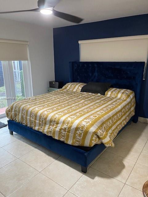 9230 SW 100th Ave Rd, Miami, FL 33176 - bedroom featuring light tile patterned flooring, a closet, ensuite bath, and baseboards