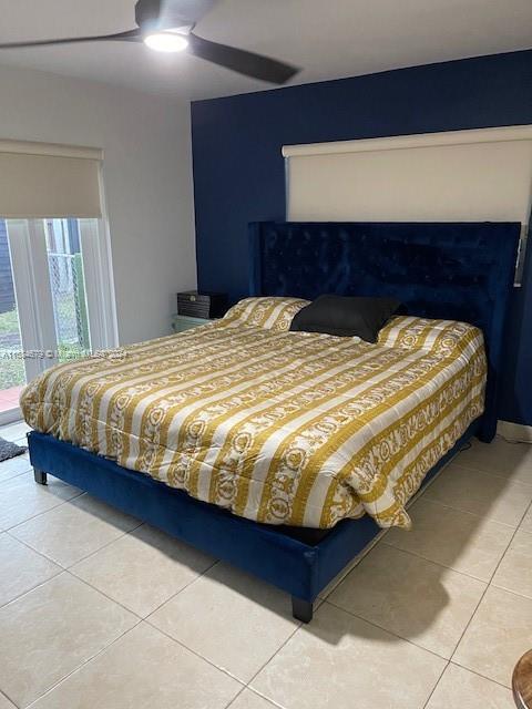 tiled bedroom featuring ceiling fan