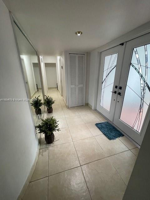 doorway to outside featuring light tile patterned flooring and french doors