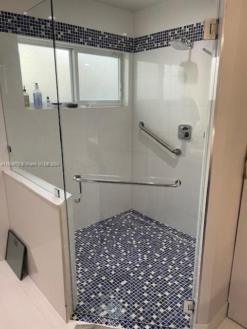 bathroom with tile patterned flooring and a shower with shower door