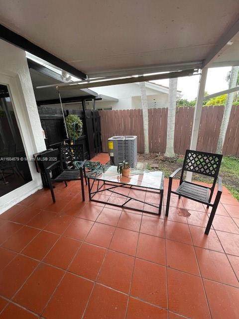 view of patio featuring central air condition unit and fence