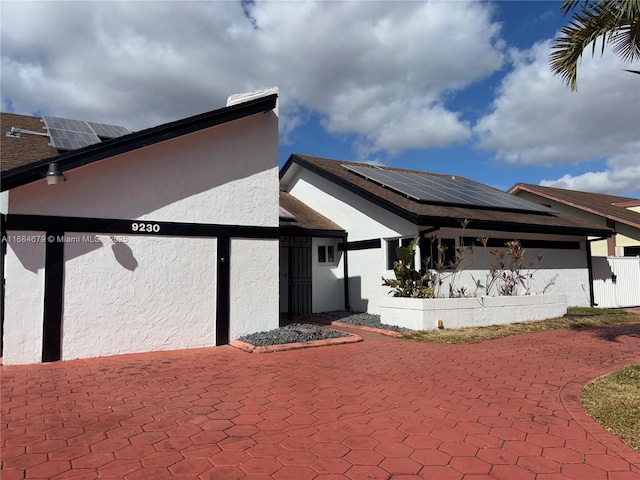 9230 SW 100th Ave Rd, Miami, FL 33176 - rear view of property featuring stucco siding and roof mounted solar panels