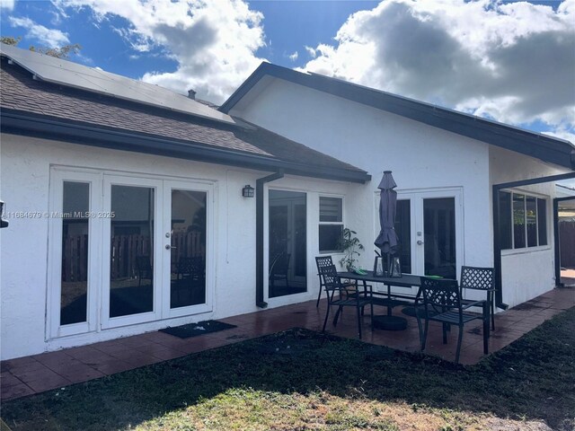 9230 SW 100th Ave Rd, Miami, FL 33176 - rear view of house featuring french doors, a patio area, roof mounted solar panels, stucco siding, and a shingled roof