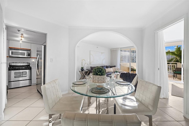 dining area with a wealth of natural light, ornamental molding, and light tile patterned flooring