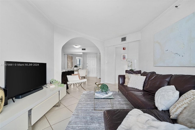 living room featuring ornamental molding and light tile patterned flooring