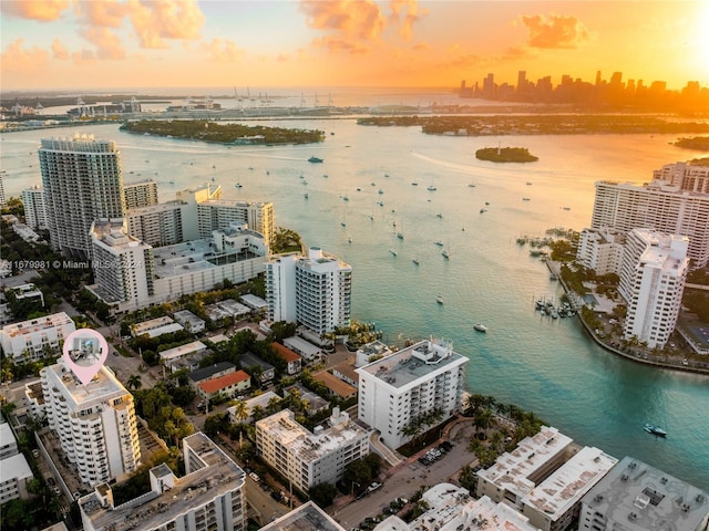 aerial view at dusk featuring a water view