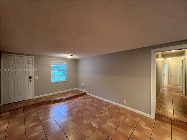 entryway with a textured ceiling and light tile patterned floors