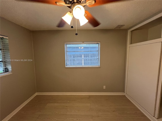 interior space featuring ceiling fan, a textured ceiling, and hardwood / wood-style floors