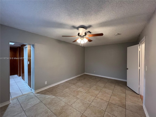 tiled spare room featuring a textured ceiling and ceiling fan