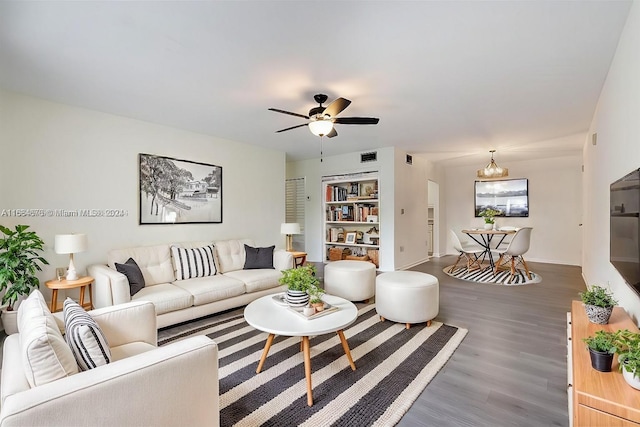 living room featuring ceiling fan with notable chandelier and dark hardwood / wood-style flooring