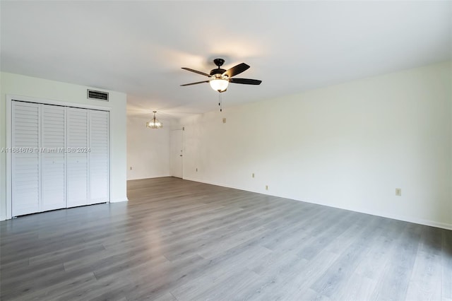 interior space with wood-type flooring and ceiling fan with notable chandelier