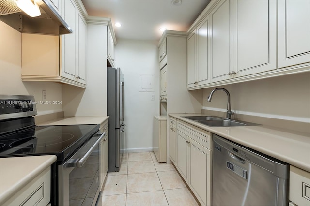 kitchen with light tile patterned floors, stainless steel appliances, extractor fan, and sink