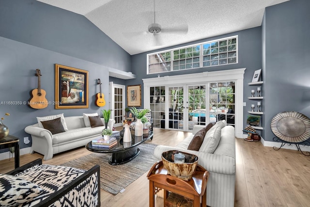 living room with french doors, high vaulted ceiling, light wood-type flooring, and ceiling fan