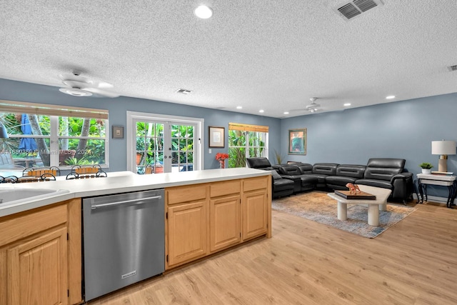 kitchen featuring light hardwood / wood-style floors, light brown cabinetry, a textured ceiling, and stainless steel dishwasher