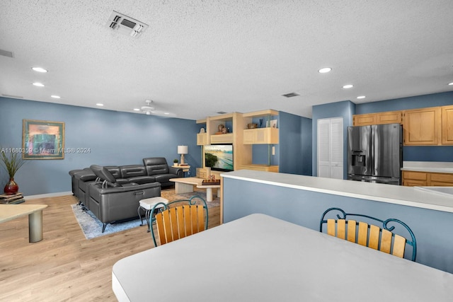 dining room with a textured ceiling and light wood-type flooring