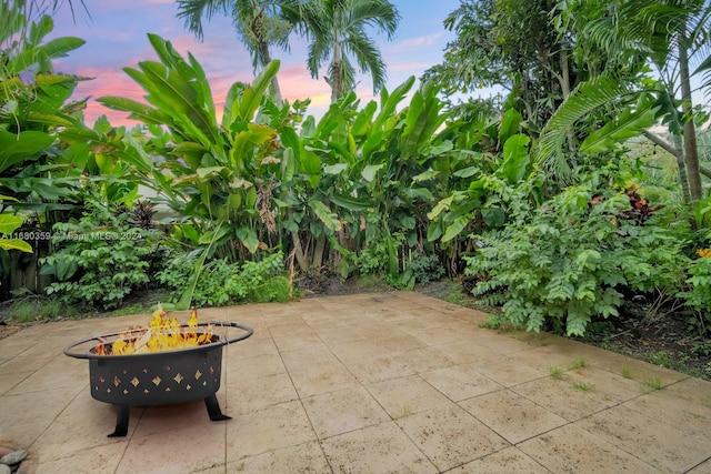 patio terrace at dusk featuring an outdoor fire pit