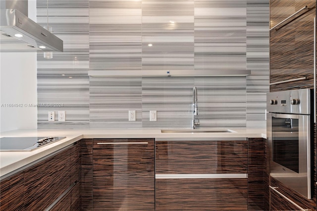 kitchen with oven, sink, ventilation hood, and stovetop