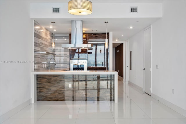 kitchen featuring oven, tasteful backsplash, light tile patterned floors, island range hood, and sink