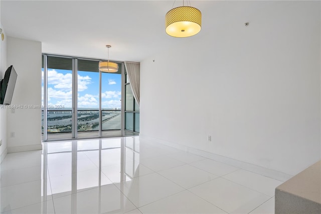 tiled spare room featuring expansive windows