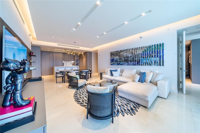 living room with a tray ceiling and light tile patterned floors